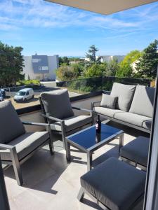 a patio with two chairs and a table on a balcony at Apartment Mare D with a pool new in Novalja