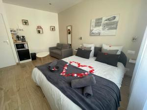a bedroom with a large bed with red flowers on it at Le Bourget - Envolée Romantique in Narbonne