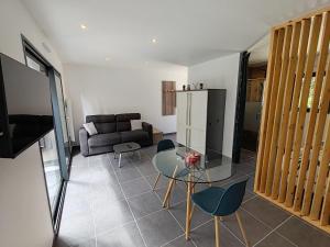 a living room with a couch and a glass table at LEntre-Deux Week-ends in Cléguer