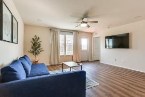 a living room with a blue couch and a tv at Modern Home with Private Yard and Patio in Little Elm! in Navo