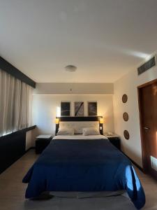 a bedroom with a large bed with a blue blanket at Hotel Beneficência Bela Vista Com Garagem 1004 in Sao Paulo