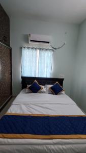 a bedroom with a large bed with blue pillows at Sree Vishnu Homestay in Tirupati