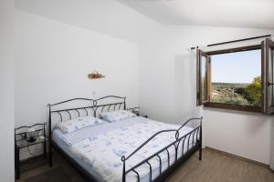 a white bedroom with a bed and a window at Ferienhaus Captains in Vintijan