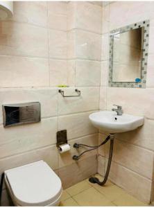 Un baño con un inodoro blanco y un lavabo. en Blueberry Residency, en Nueva Delhi