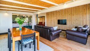 sala de estar con mesa de madera y muebles de cuero en Wilderness on Sea, en Wilderness