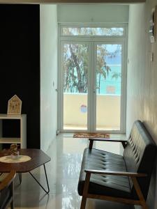 a living room with a couch and a table and a window at Spacious 3 bed seaview apartment in Flic-en-Flac