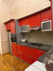 a kitchen with red cabinets and a stove at Mehrz Globway services in Baku