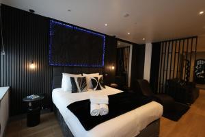 a bedroom with a large bed with towels on it at Luxury Flat,Sauna, Jacuzzi, Free Parking in Finchley