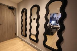 three mirrors on the wall of a living room at Luxury Flat,Sauna, Jacuzzi, Free Parking in Finchley +10 photos