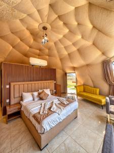 a bedroom with a large bed with a wooden ceiling at Rum Crystal luxury camp in Wadi Rum