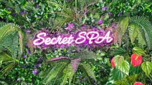 a sign that says secret spy in the middle of plants at Secret SPA Jacuzzi & Cinema in Grenoble