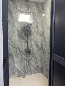 a shower in a bathroom with a stone wall at Spacious 3 bed seaview apartment in Flic-en-Flac +9 photos