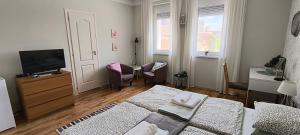a room with two beds and a flat screen tv at City Inn Szigetvar in Szigetvár