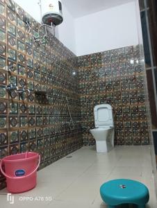 a bathroom with a toilet and a wall of tiles at Panchkedar resort in Sonprayag