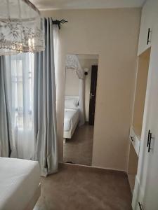 MbitaにあるLakeview Apartments - Cozy Greyのベッドルーム1室(鏡、ベッド1台付) +3枚の写真