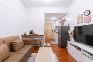 a living room with a couch and a kitchen at 1BR Condo with Free Parking at SMDC Trees Residences, Fairview Quezon City in Manila