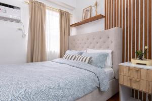 a bedroom with a bed with a blue comforter at 1BR Condo with Free Parking at SMDC Trees Residences, Fairview Quezon City in Manila +21 photos