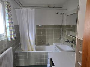 a bathroom with a bath tub and a sink at Alegria Beatenberg in Beatenberg +26 photos
