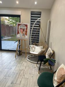 ein Wohnzimmer mit einem Gemälde eines Mannes in der Unterkunft Maison Chic à 10min du circuit des 24H in Allonnes + 2 Fotos