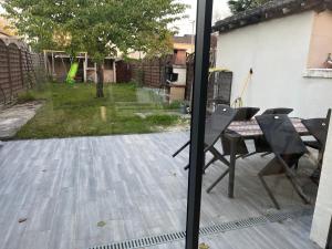 eine Terrasse mit Tisch und Stühlen in einem Hof in der Unterkunft Maison Chic à 10min du circuit des 24H in Allonnes