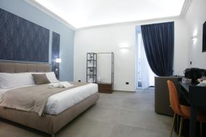 a bedroom with a large bed and a table and a desk at Pignasecca Domus in Naples