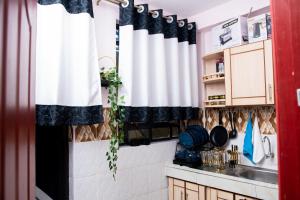 a kitchen with black and white curtains and a sink at HeritageLuxuryHomes in Gitura +4 photos