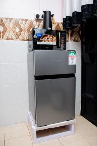 a refrigerator with a pizza on top of it at HeritageLuxuryHomes in Gitura