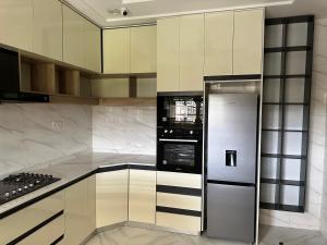 a kitchen with white cabinets and a refrigerator at EdenAlpha in Abuja