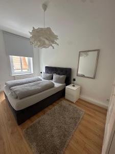 a bedroom with a bed with a mirror and a rug at Altstadtinsel am Johanneum in Lübeck