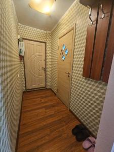 a hallway with a door and a wooden floor at Апартаменты на Новых Домах in Kharkiv