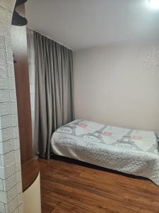a small bedroom with a bed and a window at Апартаменты на Новых Домах in Kharkiv