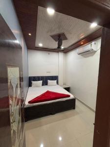 a bedroom with a bed with a red blanket on it at Annapurna Hotel in Ujjain +8 photos