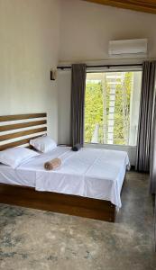 a bedroom with two beds and a large window at Вилла с бассейном и видом на рисовые поля и джунгли in Weligama