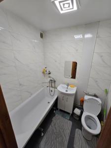 a bathroom with a tub and a toilet and a sink at 1 кімнатна квартира в центрі міста in Sumy