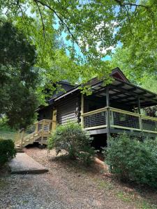 een blokhut met een grote veranda en een terras bij Mountain Tranquility Romantic-Hot Tub-Cabin -View in Helen