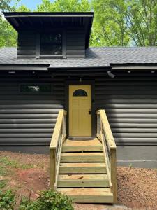 een huis met een gele deur en een trap ervoor bij Mountain Tranquility Romantic-Hot Tub-Cabin -View in Helen