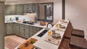 a kitchen with green cabinets and a table with food on it at Glacier Lodge - East in Steamboat Springs +16 photos