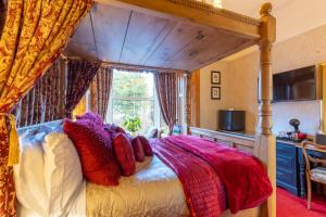 a bedroom with a canopy bed with a window at Brooklands 5 Star Guest House in Penrith