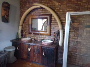 a bathroom with two sinks and a brick wall at Panthera Lodge in Marloth Park