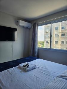a bedroom with a bed and a large window at Ap da Familia - SLZ in São Luís