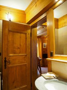 a bathroom with a wooden door and a sink at Courmayeur Cozy Nest in Courmayeur +12 photos