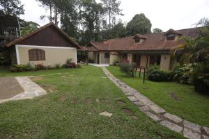 a house with a grass yard in front of it at Sítio Bem me Quer seu conforto e relax na Serrinha in Penedo