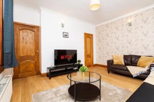 ein Wohnzimmer mit Couch und Fernseher in der Unterkunft 2Bed Upper Cottage Flat-On Street Parking in Falkirk + 13 Fotos