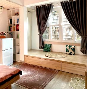 a window seat in a room with a bed and two windows at Aurora Homestay in Hanoi