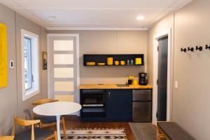 cocina con mesa, mesa pequeña y sillas en Modern Tiny House with hot tub & river near Stowe, en Johnson