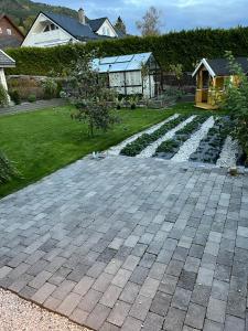 Un patio trasero con un patio de piedra y un jardín. en Sandvik Garasjeloft, en Vossevangen