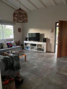 een woonkamer met een bank en een tv bij La Casa del Gringo in Villa Icho Cruz