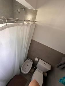 een badkamer met toilet en douchegordijn bij La Casa del Gringo in Villa Icho Cruz +3 foto's