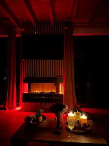 a fireplace in a room with a table and candles at Cabana Tei-Tei in Izvoarele