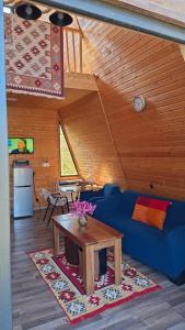 a living room with a blue couch and a table at Qiwi Cottege Mzetamze in Timotisubani